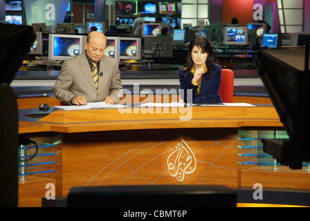 Télévision par satellite Al Jazeera anchors Habib Ghribi et Lina Zahreddine lire un bulletin de nouvelles du studio à Doha, Qatar Banque D'Images