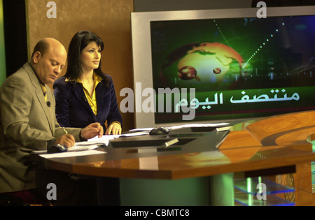 Télévision par satellite Al Jazeera anchors Habib Ghribi et Lina Zahreddine lire un bulletin de nouvelles du studio à Doha, Qatar Banque D'Images