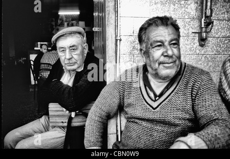 Dur et rugueux vieux pêcheurs se détendre dans un bar dans le village de Olmao dans l'Algarve au sud du Portugal dans l'Europe Banque D'Images