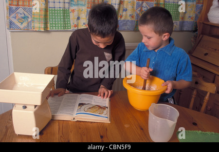 Deux jeunes garçons faire des crêpes Banque D'Images