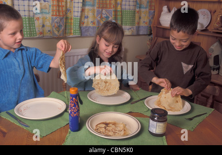 Trois enfants de manger des crêpes qu'ils ont fait (série) Banque D'Images