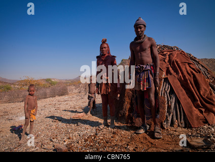 Famille Himba en face de leur hutte, Angola Banque D'Images