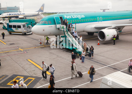 Les passagers débarquant d'avion Aer Lingus sur l'aire de trafic de l'aéroport de Cork. Le comté de Cork, en République d'Irlande. Banque D'Images