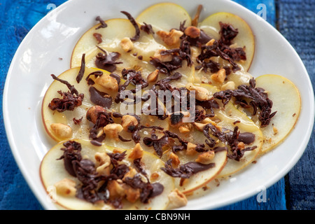 Les pommes avec le caramel et le sirop d'érable et crème fouettée, chocolat et noisettes grillées au Limoncello Banque D'Images