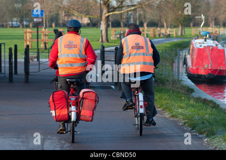 Deux facteurs sur leurs vélos le long de la rivière Cam à Cambridge. L'Angleterre. Banque D'Images