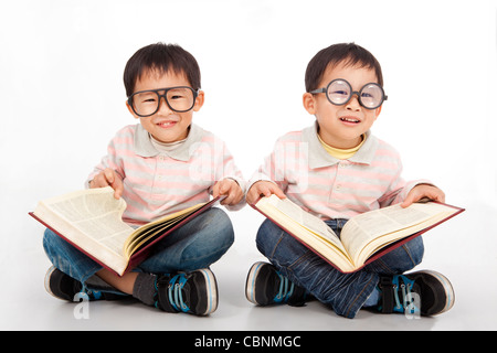 Enfants heureux avec gros livre portant lunettes noires Banque D'Images