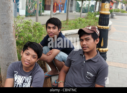 Les ados heureux de détente près de la rivière Melaka. Banque D'Images