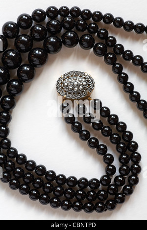 Collier de perles noires avec fermoir décoratif isolé sur fond blanc Banque D'Images