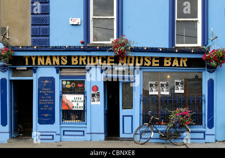 Vue frontale/tynans bar bridge house kilkenny Irlande pub établissements titulaires d'attraction bleu vélo panier de fleurs Banque D'Images