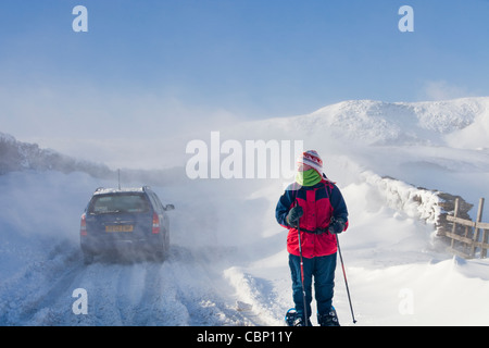 Une voiture est abandonnée sur l'Kirkstone pass road Windermere ci-dessus après qu'il est bloqué par la neige par le vent et les embruns, Banque D'Images