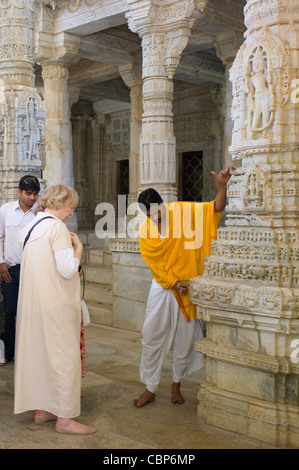 Prêtre du Temple montre les touristes de la sculpture sur pierre au temple Ranakpur Jain à Desuri Tehsil du Rajasthan, Inde Banque D'Images