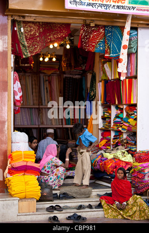 Famille indienne shopping pour les vêtements pour enfants dans la vieille ville à Udaipur, Rajasthan, Inde de l'Ouest Banque D'Images