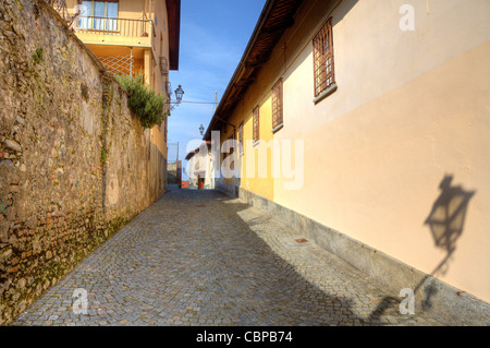 Rue étroite pavée entre les maisons anciennes et les murs de la ville de Saluzzo, Italie du nord. Banque D'Images