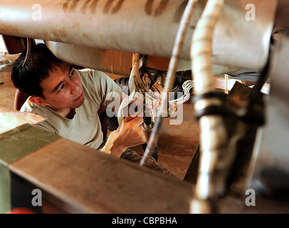 Airman de 1ère classe Francisco Ortiz répare les fils afflés par la corrosion sur un HH-60G Pave Hawk 2 novembre 2011, à la base aérienne de Kadena, au Japon. Francisco est un écologiste électrique du 718e Escadron de maintenance d'aéronefs. Banque D'Images