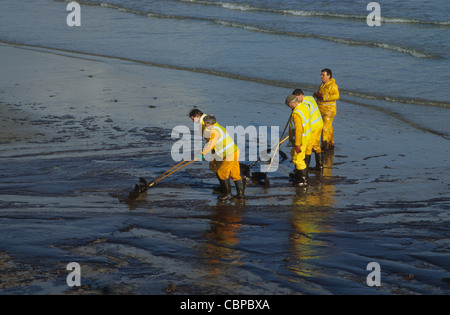 Les ouvriers nettoyant le pétrole brut au large de la plage après l'échouement du pétrolier Sea Empress. Pembrokeshire. Banque D'Images