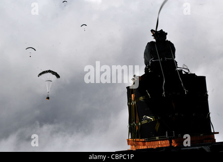 Un faisceau de parachute avec système de chute d'air de précision interarmées est déposé d'un Hercules C-130J à une base d'exploitation avancée éloignée, le 27 novembre 2011. Le système JPAD utilise un système de navigation GPS pour guider les faisceaux de parachute vers des zones de chute précises, réduisant ainsi les dommages collatéraux, les déplacements au sol des troupes et la vulnérabilité des embarcations aériennes. Banque D'Images