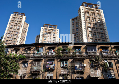 Ancien immeuble traditionnel dans le logement de l'ombre de nouveaux blocs d'appartements moderne de haute élévation à Mahalaxmi dans Mumbai, Inde Banque D'Images