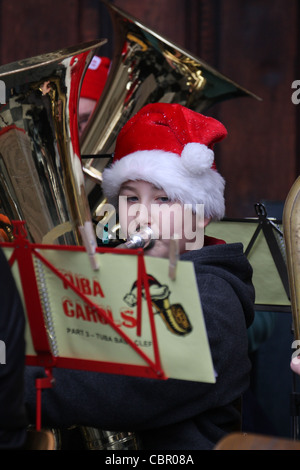 Un joueur de tuba avec un chapeau de Père Noël se lit de la musique des chants de Tuba feuille à la Cathédrale St Paul. © David Mbiyu/Alamy Live News Banque D'Images