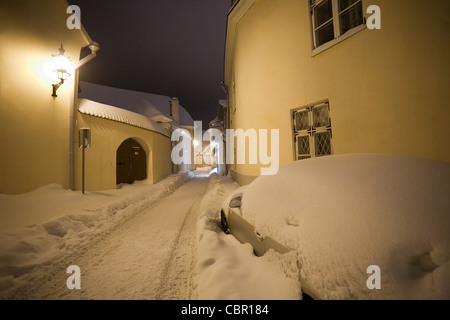 Vide nuit rue étroite couverte de neige dans la vieille ville de Vilnius, Lituanie Banque D'Images