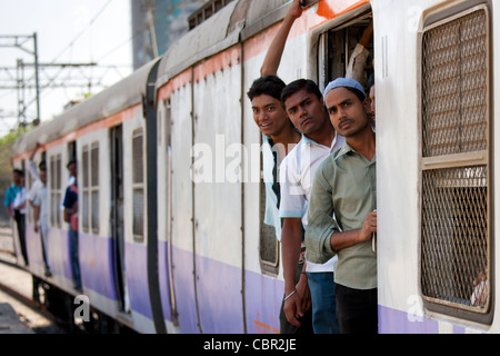 Travailleurs sur les trains de banlieue bondés de la gare ferroviaire de l'Ouest près de Mahalaxmi Mumbai sur le rer, Inde Banque D'Images