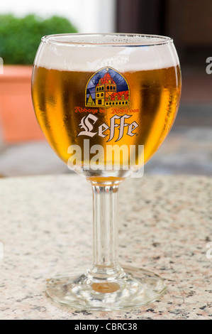 Close up vertical d'une Leffe blonde bière dans un gobelet en verre de forme traditionnelle. Banque D'Images