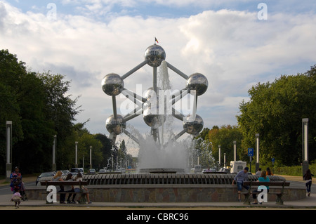 Vue horizontale de l'Atomium monument situé dans le parc du Heysel avec les touristes assis par les fontaines sur le boulevard du Centenaire. Banque D'Images