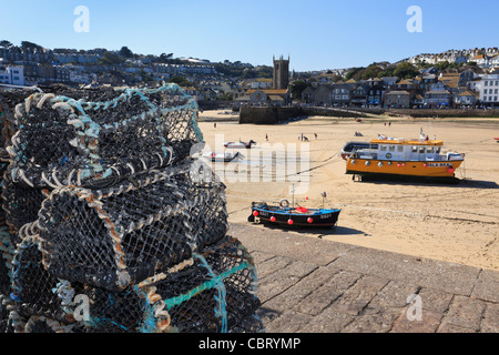 La Nasse de homard sur le mur du port avec bateaux amarrés à marée basse dans petit port de pêche. St Ives, Cornwall, England, UK Banque D'Images