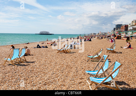 Les baigneurs et les nageurs soleil détente sur la plage de Brighton, en Angleterre. Banque D'Images