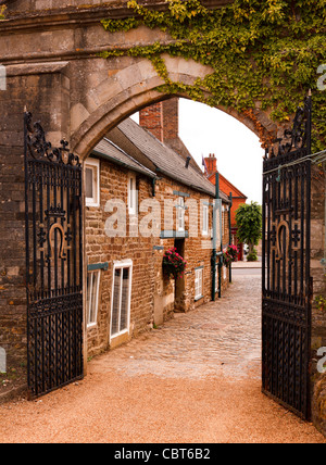 Arche en pierre et portes en fer forgé à l'entrée dans l'enceinte de la Grande Salle du château d'Oakham, Oakham, Rutland, Angleterre, Royaume-Uni Banque D'Images