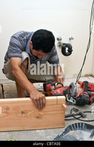 Homme hispanique du Mexique travailler sa propre entreprise de construction aux Etats-Unis remplace-support dans la salle de bains à l'étage aux USA. M. © Banque D'Images