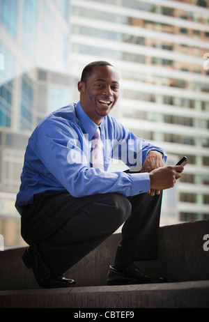 Black businessman holding cell phone Banque D'Images