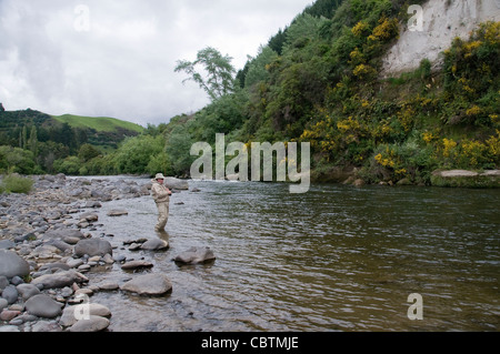 Un pêcheur bénéficie de l'action de pêche à la truite sur une petite rivière de la Nouvelle-Zélande dans la région du lac Taupo sur l'Île du Nord. Banque D'Images