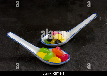 Les cuillères plein de bonbons colorés Banque D'Images