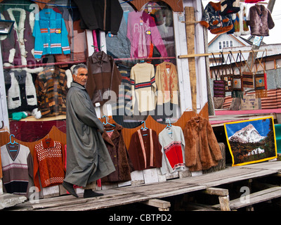 Un commerçant du cachemire dans une boutique de cadeaux et textiles dans le lac Dal's marché flottant. Banque D'Images