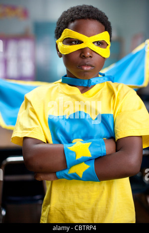 African American boy wearing superhero costume in classroom Banque D'Images