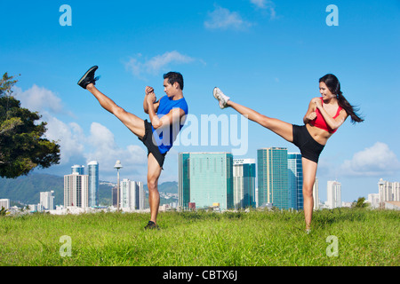 Couple exercising together in field Banque D'Images