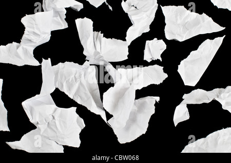 Des morceaux de morceaux de papier froissé bureau isolé sur fond noir Banque D'Images