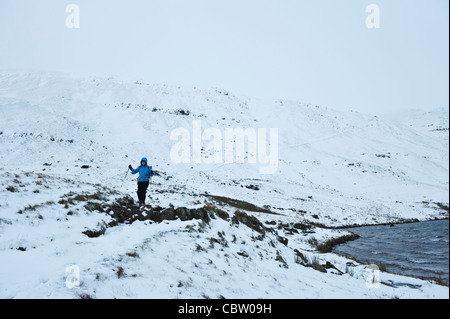 Female hiker près de Llyn y Fan Fawr en hiver, Black Mountain, parc national de Brecon Beacons, le Pays de Galles Banque D'Images