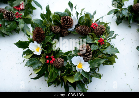 Fait à la main traditionnel houx de Noël couronnes en vente sur un marché de fermiers, au Royaume-Uni. Banque D'Images