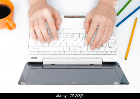 Vue de dessus sur le lieu de travail avec ordinateur portable et mains femme saisie sur elle Banque D'Images