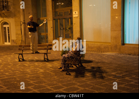 Mari apporte une sérénade à sa femme pendant la nuit au square à Syracuse, Sicile, Italie, drôle, romantique Banque D'Images