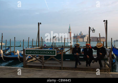 Gondoliers attendent au bord de Molo ride en face de la baie de Bacino di San Marco Venise Italie Banque D'Images