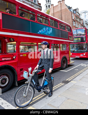 Businessman on location avec double-decker bus, Londres, Angleterre Banque D'Images