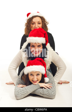 Happy three friends with Santa hat située au-dessus les uns les autres sur le plancher et de s'amuser Banque D'Images
