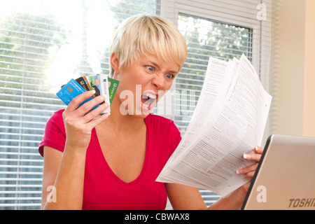 Femme choquée par des relevés de carte de crédit Banque D'Images