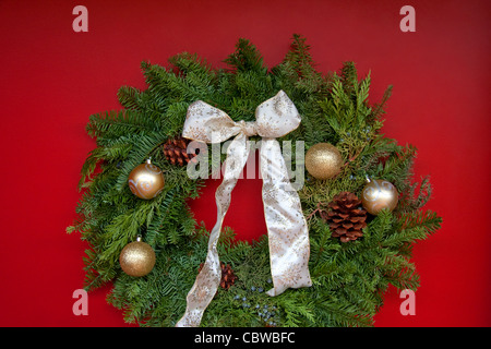 Couronne de Noël accroché sur la porte rouge Banque D'Images