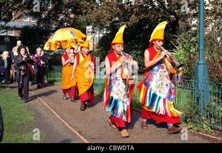 Le chant des moines tibétains et de jouer des instruments de musique avant de commencer à créer un mandala de sable Chenresig à Brighton, UK Banque D'Images