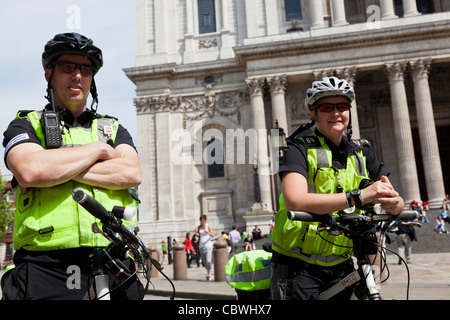 Police woman and Community Support Officer sur des vélos, Londres. Banque D'Images