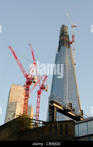 Le fragment d'être complété par deux grues rouges le tesson est 310 m. 1017ft 32 London Bridge London UK Banque D'Images