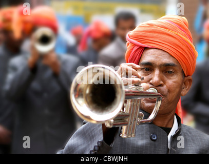 L'homme indien avec turban orange à jouer de la trompette à un festival de rue. Pushkar. Le Rajasthan. L'Inde Banque D'Images